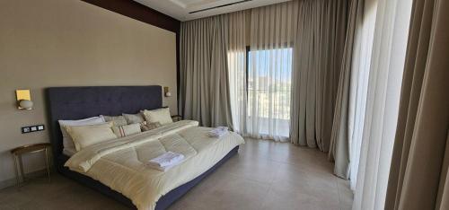 een slaapkamer met een groot bed en een groot raam bij Exceptional villa with pool in Sendou in Siendou