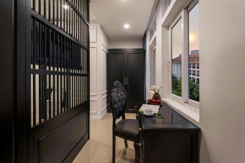 een hal met een zwarte deur en een stoel en een bureau bij The Elegant Boutique - Hue in Hue