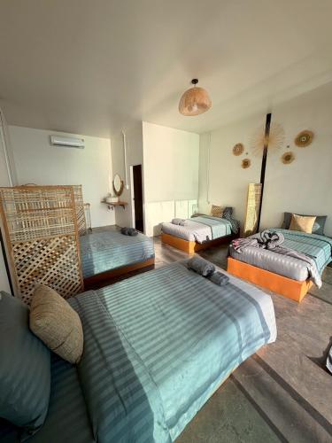 a living room with three beds and a couch at Malila Sea Breeze Hostel in Ko Tao