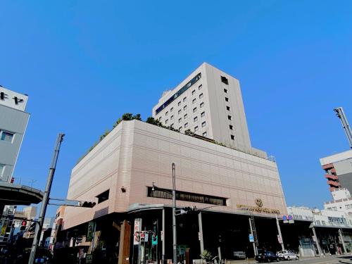 a tall white building on a city street at Koriyama View Hotel Annex in Koriyama