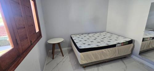 a small room with two beds and a stool at Casa Temporada Conchinha do Mar in São Mateus