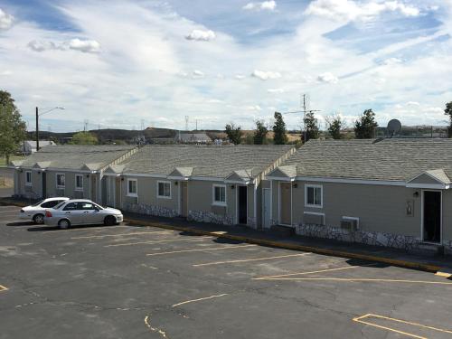 a row of houses with a car parked in a parking lot at Umatilla Inn & Suites in Umatilla