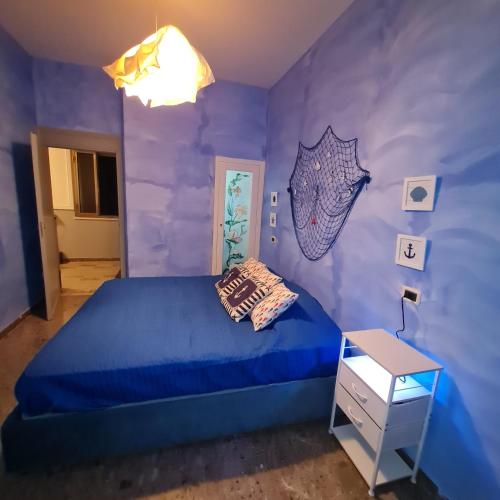 a bedroom with a blue bed and a purple wall at Ocean View House in Nettuno