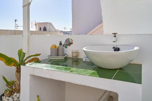 un bagno con un lavandino a ciotola su un bancone di Casa El Camaleón ad Almuñécar