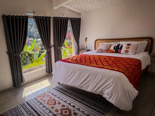 una camera da letto con un letto e una grande finestra di Little Munduk, full private villa a Munduk