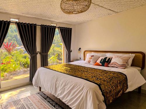 una camera da letto con un letto con una grande finestra di Little Munduk, full private villa a Munduk