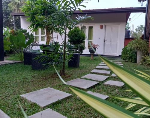 een tuin met stapstenen en een huis bij Dhanashi Villa Talalla in Talalla South