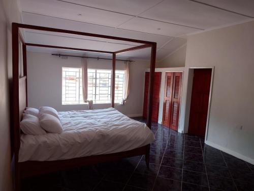 una camera con letto e struttura in legno di Cosy Three Bedroom Home a Livingstone