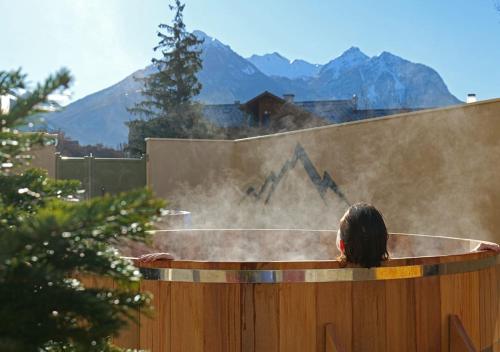 a woman is standing in a hot tub with smoke at Garrigae Caserne de Briançon & SPA Cinq Mondes in Briançon