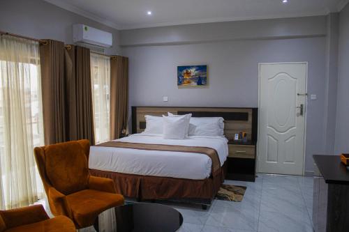 ein Hotelzimmer mit einem Bett und einem Stuhl in der Unterkunft LENNON QUALITY Hotel in Umtali