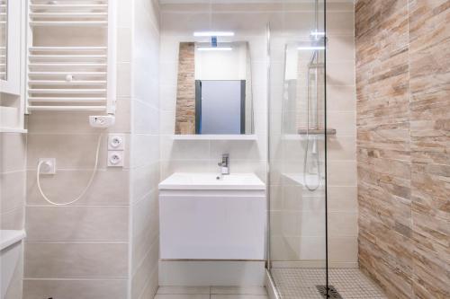 une salle de bain blanche avec lavabo et douche dans l'établissement Grand Studio front de mer - Climatiser avec place de parking, à La Celle-sous-Gouzon