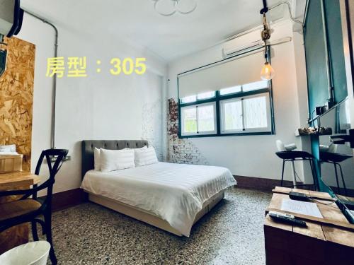 een slaapkamer met een bed, een spiegel en een bureau bij 阡陌-分享民宿 in Tainan
