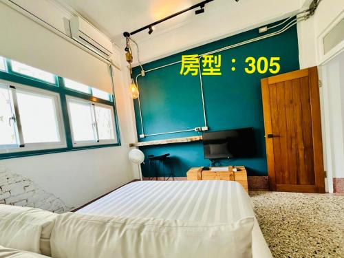 een slaapkamer met een bed en een tv erin bij 阡陌-分享民宿 in Tainan