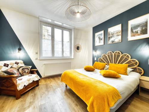 een slaapkamer met een bed met gele lakens en een stoel bij Au jardin de la Basilique in Boulogne-sur-Mer