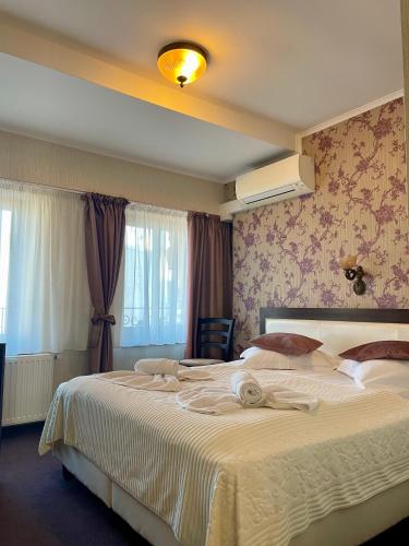 ein Hotelzimmer mit einem großen Bett, auf dem Handtücher lagen in der Unterkunft Villa Anticus (Adults Only) in Constanţa