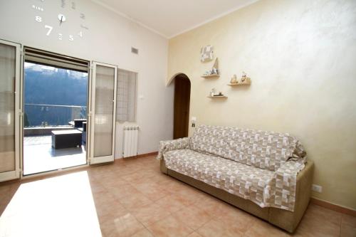 een woonkamer met een bank en een glazen schuifdeur bij Raggio di Sole Apartment in Valmontone