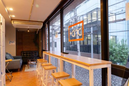 eine Bar in einem Restaurant mit Stühlen und einer Theke in der Unterkunft bnb+ Secret Base Mejiro in Tokio