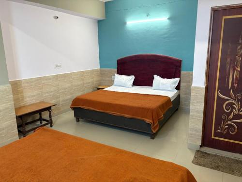 a bedroom with a bed and a chair in it at Hotel Mohan in Agra