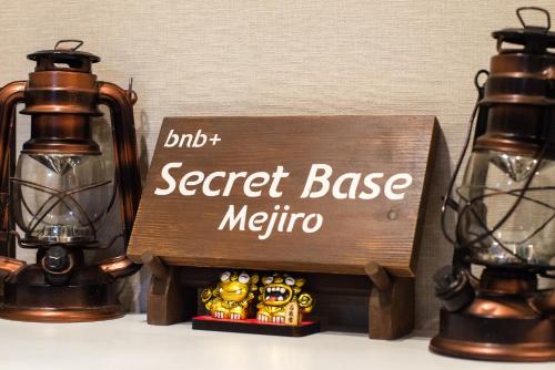 a secret base metro sign next to two lights at bnb+ Secret Base Mejiro in Tokyo