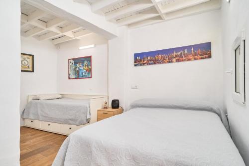 ein weißes Schlafzimmer mit zwei Betten und einem Fenster in der Unterkunft Cortijo Palomo in Benamocarra