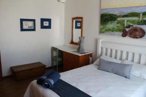 une chambre avec un lit et un miroir au mur dans l'établissement Die Dik Vis, à Velddrif