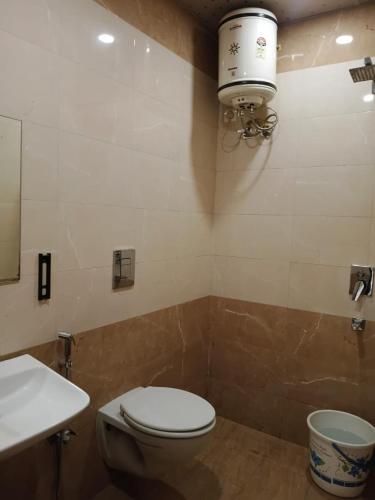 a bathroom with a toilet and a sink and a light at Hotel Ram Bhawan in Lucknow