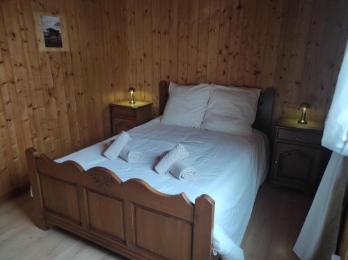 een slaapkamer met een bed met witte lakens en 2 lampen bij Location d'un chalet de vacances in Pont-de-Poitte