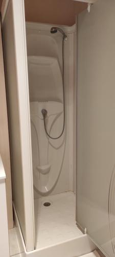 een douche met een slang in een witte badkamer bij Location d'un chalet de vacances in Pont-de-Poitte