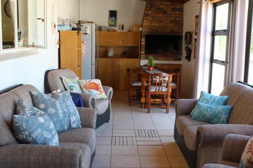 un salon avec deux canapés et une cuisine dans l'établissement Die Dik Vis, à Velddrif