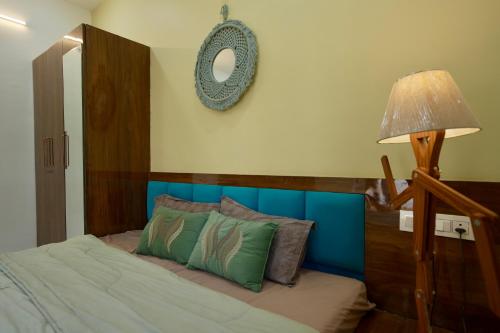 een slaapkamer met een bed met een houten hoofdeinde en een spiegel bij Captain Go-Go 1 bhk apartment in Indore
