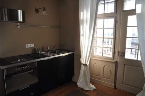 cocina con fregadero y puerta con ventana en Chambres d'hôtes Le Clos Saint Léonard, en Boersch