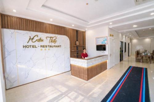 Die Lobby eines Hotelrestaurants, in der eine Frau an einem Tresen steht. in der Unterkunft Hiếu Thảo Hotel & Restaurant Sầm Sơn in Sầm Sơn