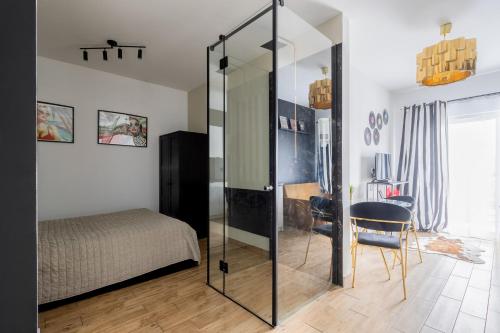 een slaapkamer met een glazen deur naar een bed bij Wyjątkowy apartament z prysznicem pośrodku na wyjątkowe wieczory in Łódź
