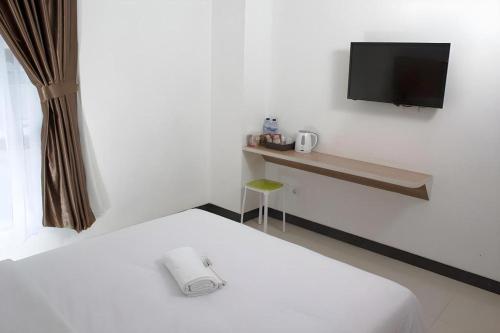 una camera da letto con un letto e una TV a parete di Sakura Manado a Manado