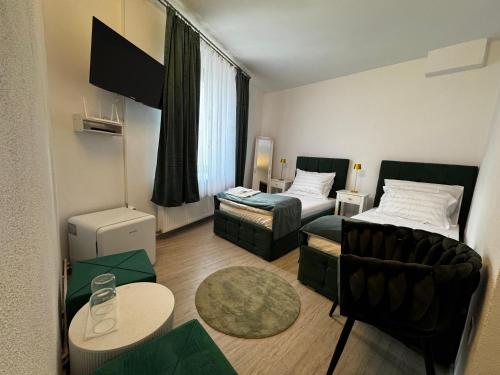 ein kleines Zimmer mit 2 Betten und einem Sofa in der Unterkunft Tudors Rooms in Mediaş