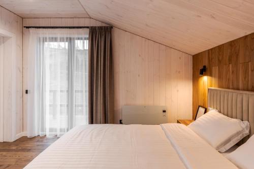 a bedroom with a large white bed and a window at Saduba y Lukasa in Oryavchyk