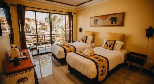 ein Hotelzimmer mit zwei Betten und Balkon in der Unterkunft Keep Diving Resort Bohol in Taporok