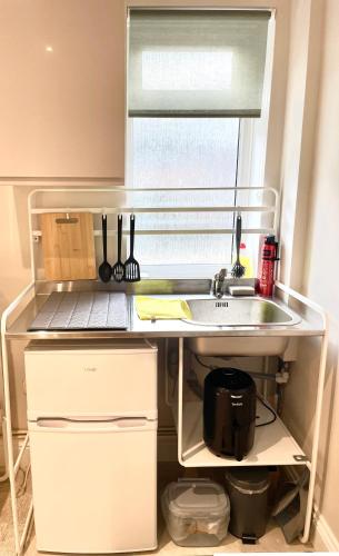 a kitchen counter with a sink and a window at Costa del Pinner in Northwood