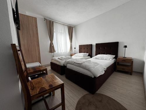 ein Hotelzimmer mit zwei Betten und einem Tisch in der Unterkunft Tudors Rooms in Mediaş