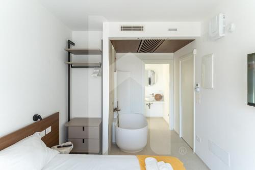 een slaapkamer met een badkamer met een bad en een bed bij Homiday - Sublimare in Giulianova