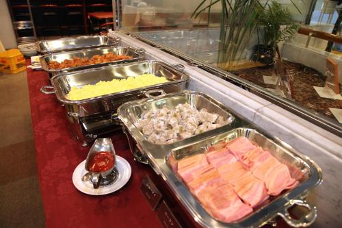 a buffet with several trays of food on a counter at Kuretake Inn Asahikawa in Asahikawa