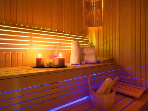 een bank in een kamer met twee kaarsen en een stoel bij Mercure Tbilisi Old Town in Tbilisi City