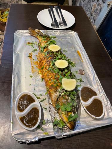 un plateau de poisson sur une table avec une sauce pour tremper dans l'établissement Rhino Spot Resort, à Meghauli