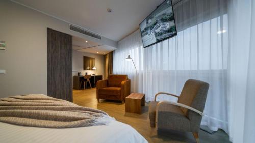 a hotel room with a bed and a chair at Hestia Hotel Strand in Pärnu