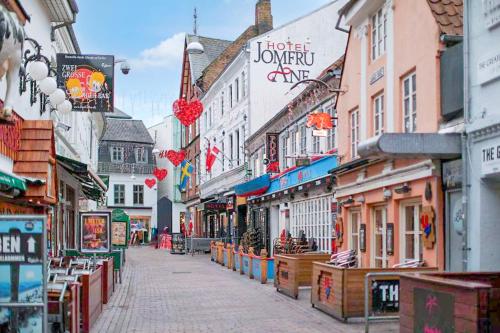 ulica w mieście z wieloma sklepami i budynkami w obiekcie Dancenter Hotel Jomfru Ane w Aalborgu