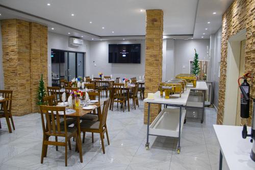 ein Speisesaal mit Tischen und Stühlen in einem Restaurant in der Unterkunft LENNON QUALITY Hotel in Umtali