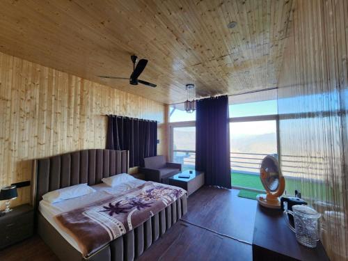 a bedroom with a large bed and a large window at Perry's Cottage in Faigul