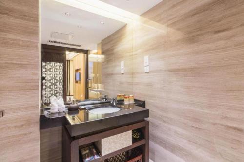 a bathroom with a sink and a mirror at Dajiuhua Hotel in Chizhou