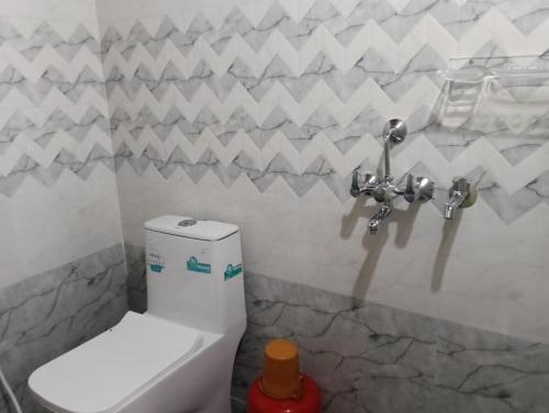 a bathroom with a white toilet in a room at Anurastays in Mudigere