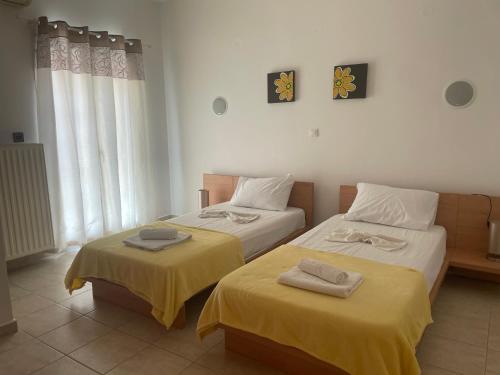 zwei Betten in einem Zimmer mit gelben Laken und Handtüchern in der Unterkunft Villa Midas in Zóla